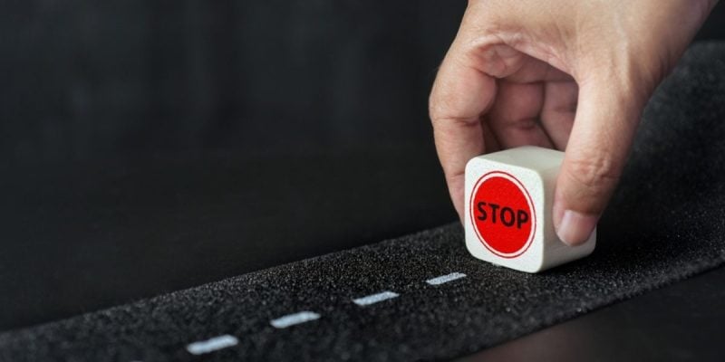 Man Holds Small Wood Block Reading 