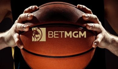 BetMGM Logo Over Close Up Image of Man Holding Basketball