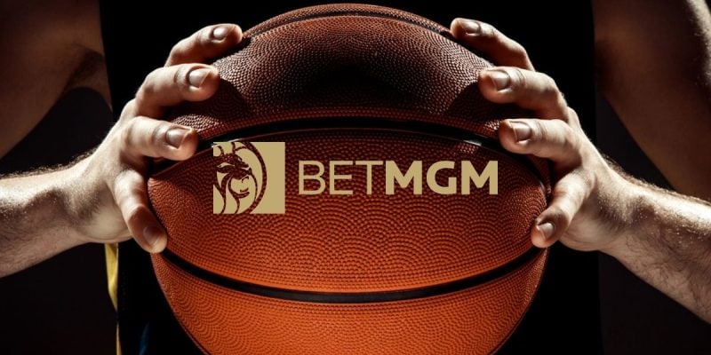 BetMGM Logo Over Close Up Image of Man Holding Basketball