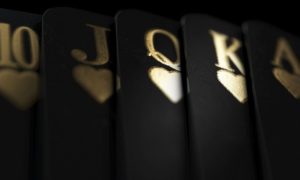 Black Playing Cards Display Royal Flush in Gold Ink