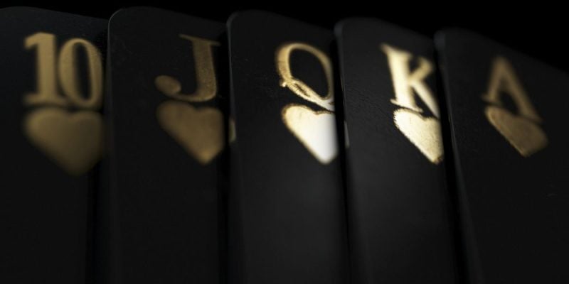 Black Playing Cards Display Royal Flush in Gold Ink