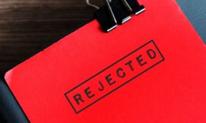 Close Up of Red Document Stamped With the Word "Rejected" In Black