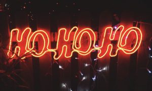 Outdoor Fence Displays Red Neon "Ho Ho Ho" Sign At Night Time