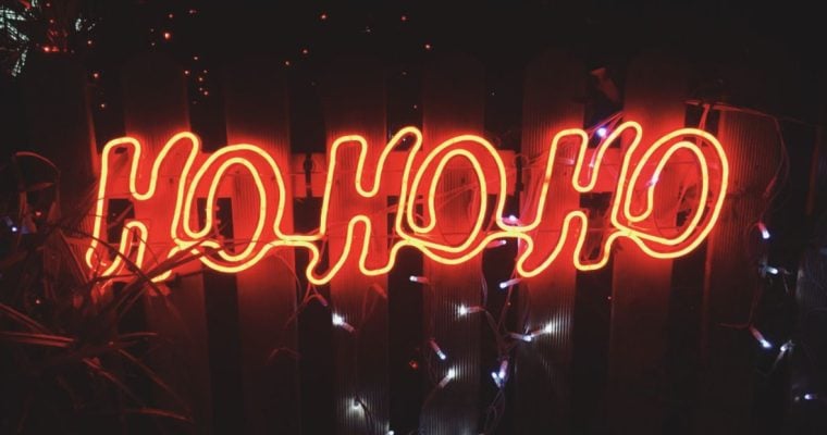 Outdoor Fence Displays Red Neon "Ho Ho Ho" Sign At Night Time