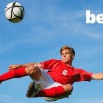 Bet365 Logo Over Image of Soccer Player Mid-Air Kicking Ball Against Blue Sky Background