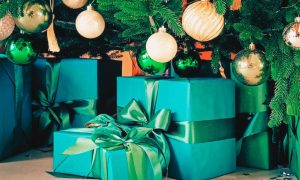 Close Up of Green Gifts Under Decorated Christmas Tree
