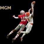 BetMGM Logo Over Image of Two Football Players in Mid-Air Jump to Catch Football