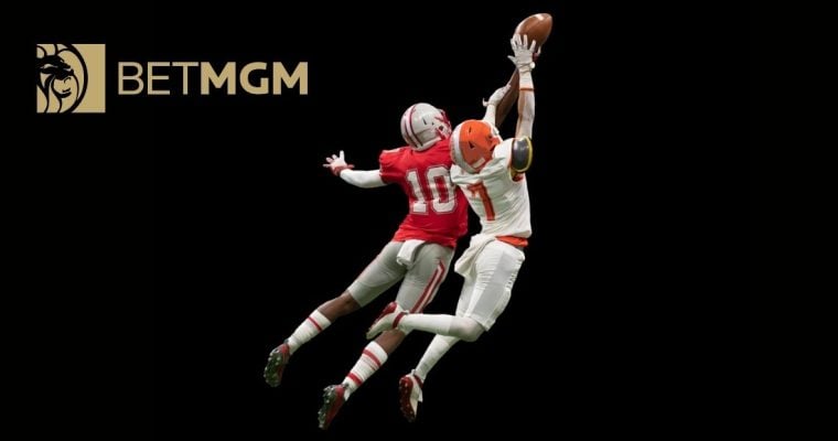 BetMGM Logo Over Image of Two Football Players in Mid-Air Jump to Catch Football
