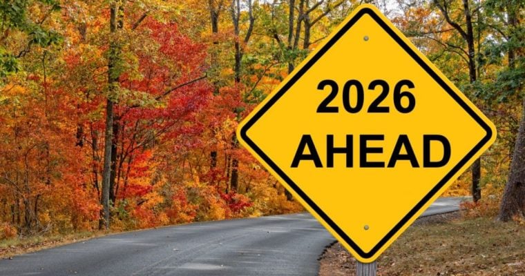 Yellow Caution Sign Reads "2026 Ahead" with Autumn-Colored Trees in Background