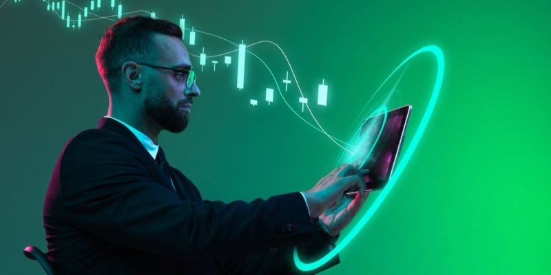 Digital Market Trends Graph Behind Business Man Using iPad