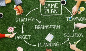 Circle of Hands Around a Game Plan On Green Grass