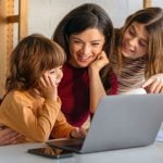 Young Children Use Laptop With Mother's Guidance