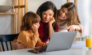 Young Children Use Laptop With Mother's Guidance