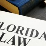 Desk Displays Books, One Open Book Has Florida Law Written Inside