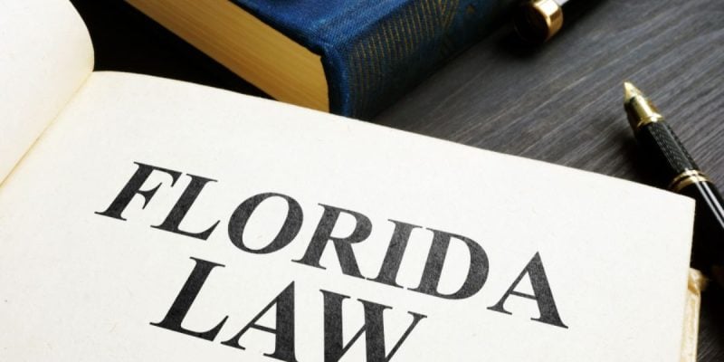 Desk Displays Books, One Open Book Has Florida Law Written Inside