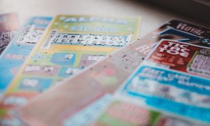 Five Colorful Used Lottery Scratch Games Laying On Top of Each Other