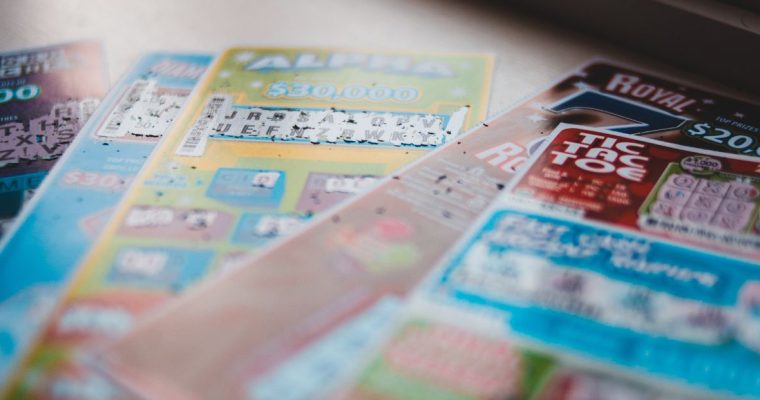 Five Colorful Used Lottery Scratch Games Laying On Top of Each Other