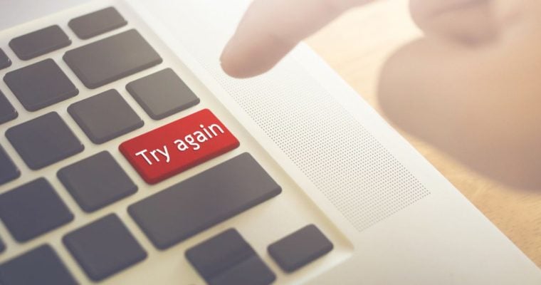 Man's Finger Set to Press Red Try Again Button on Laptop