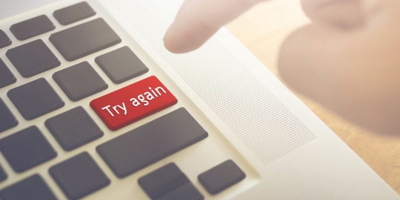 Man's Finger Set to Press Red Try Again Button on Laptop