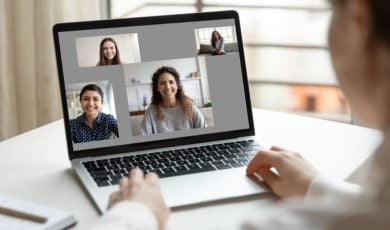 Three People Displayed on Video Call over Laptop While Woman Looks