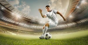 Male Soccer Player Foots Soccer Ball While On Playing Field