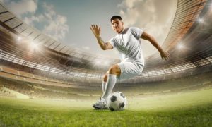 Male Soccer Player Foots Soccer Ball While On Playing Field