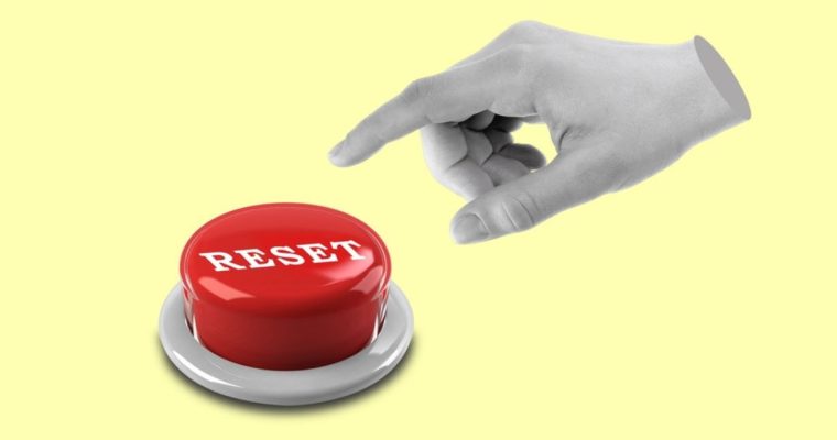 Isolated Hand Points To Red Reset Button on Yellow Background