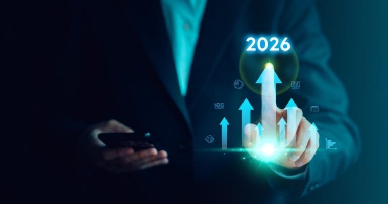 Business Man Points to Arrow with 2026 Above it While Holding Cell Phone