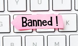 Pink Paper Reads Banned! Sitting On Top of White Keyboard