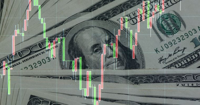 Red and Green Financial Graph Moves Up and Down Over Layed Out $100 Bills