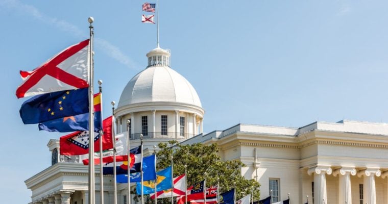 The Top of the Alabama State Capitol Building and Various State Flags Flying
