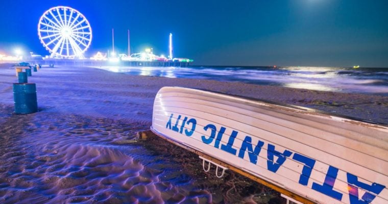 Ferris Wheel and City Lights Glow In the Background On Sandy Beach in Atlantic City, New Jersey