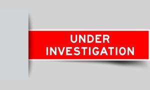 Red Label Reads Under Investigation on Solid Gray Background