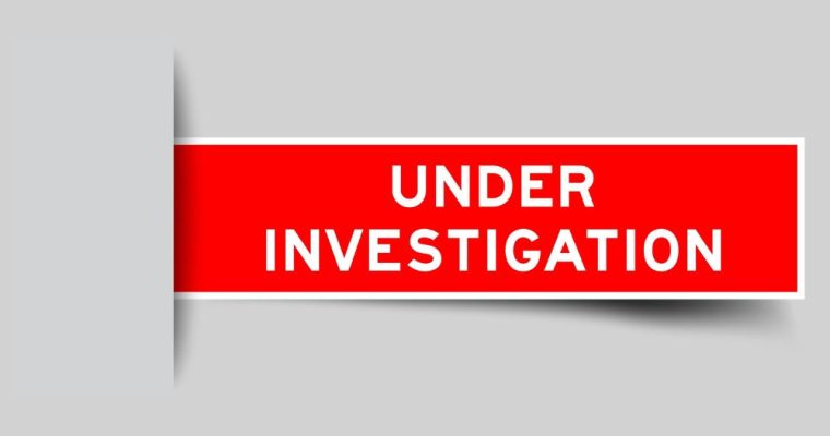 Red Label Reads Under Investigation on Solid Gray Background