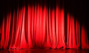 Spotlight Shines Toward Bottom of Draped Red Stage Curtain