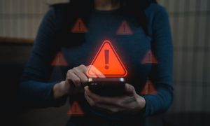 Woman Holding Cell Phone with Red Warning Icons Hovering Around It