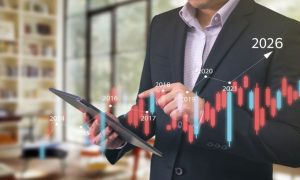 Business Man in Suit Holds Tablet with Digital Overlay of Financial Bar Chart