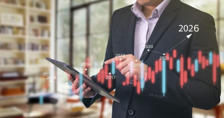Business Man in Suit Holds Tablet with Digital Overlay of Financial Bar Chart