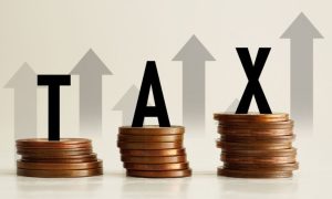 Upward Pointing Arrows Behind Stacks of Copper Coins and the Word Tax