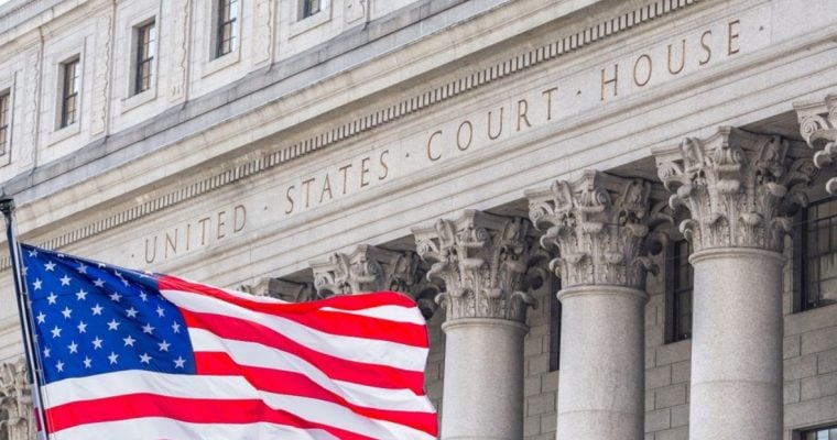 Close Up of Building Text Reading United States Court House with American Flag In Front