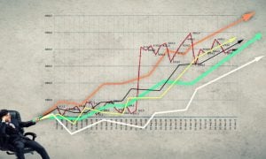 Several Multi-Colored Line Graphs with Arrows Trending Up and Man in Suit Sitting at Bottom Left Corner