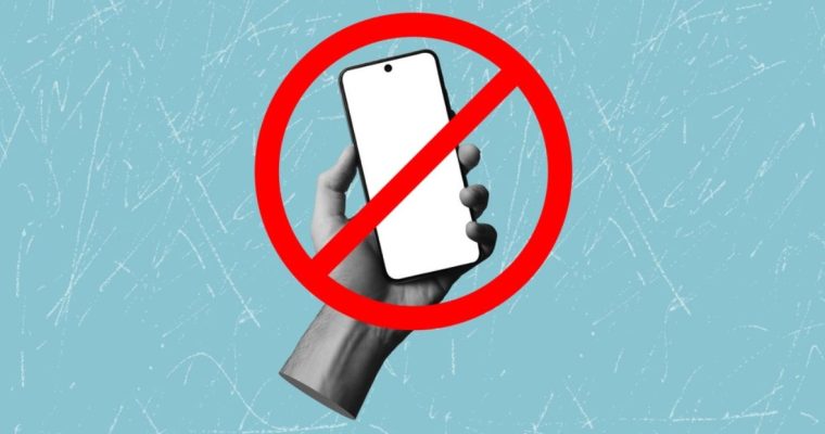 Red Banned Symbol Over Image of Hand Holding Mobile Phone with White Screen