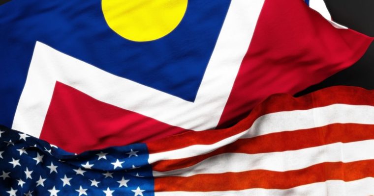 Close Up of Colorado Flag Laying Above the American Flag