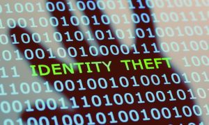 Binary Code with Identity Theft Text In the Center and Reflection of Hand