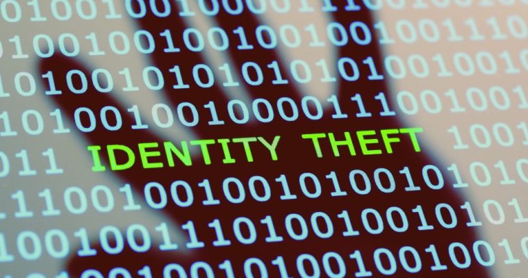 Binary Code with Identity Theft Text In the Center and Reflection of Hand