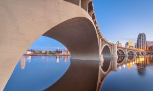 Bridge in Minnesota Shows Double Reflection in the Mississippi River Water and Cityscape Skyline