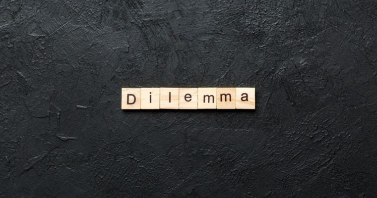 Light Wood Colored Blocks Spell Dilemma Centered on Black Background