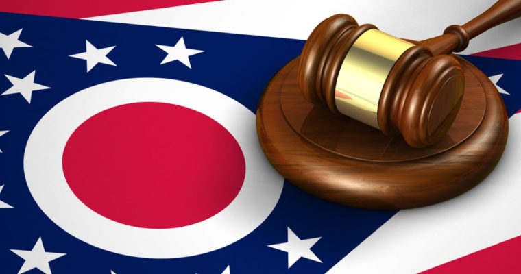 Wooden Judge's Gavel with Gold Metal Detail Sits On top of Ohio State Flag