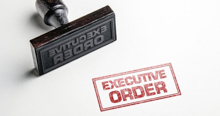 Rubber Stamp with Red Ink Says Executive Order on White Background