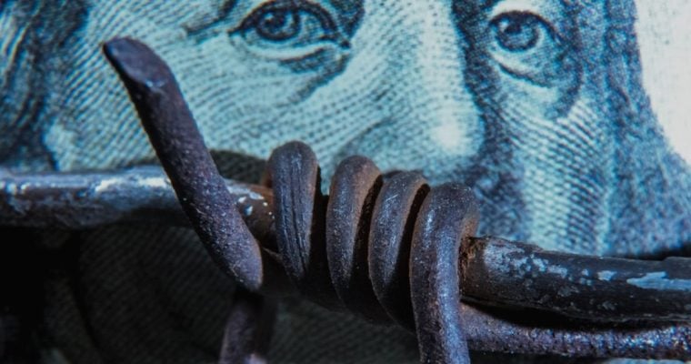 Metal Barb Wire Lays Across US Banknote Background
